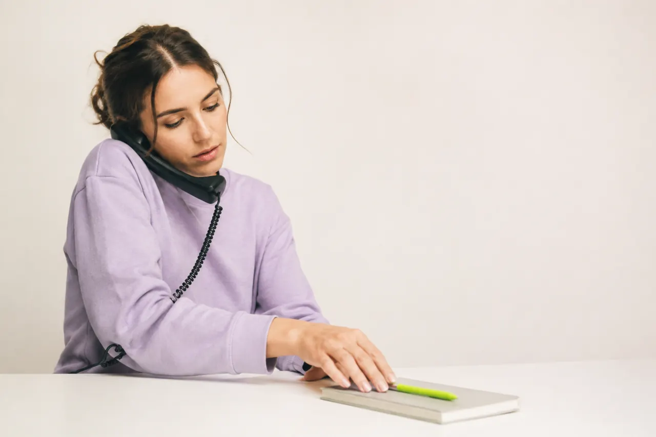 Receptionist answering a patient call and noting the booking